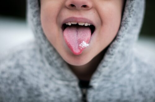 child catching snow on tongue